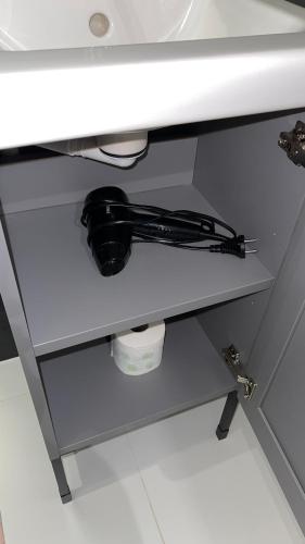 a white bathroom sink with a black cord under it at APARTHOTEL in Przemyśl