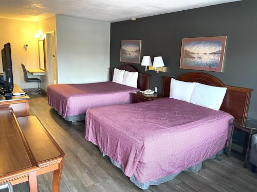 a hotel room with two beds with purple sheets at Downtown Inn in Wenatchee