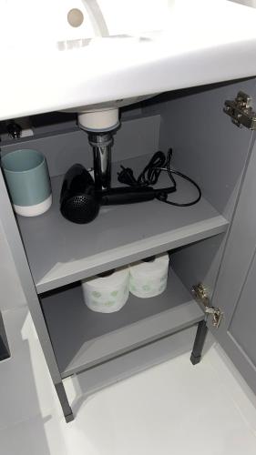 a shelf under a sink with dishes underneath it at APARTHOTEL in Przemyśl