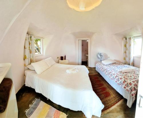 een slaapkamer met 2 bedden en 2 ramen bij Hospedagem Alternativa in Alto Paraíso de Goiás