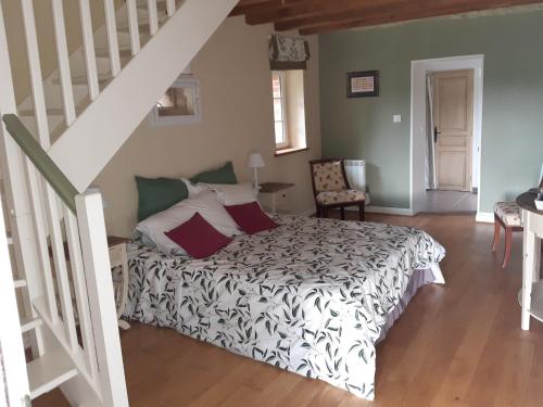 a bedroom with a bed and a staircase at Par les Prés et les Bois de Sologne in Bauzy