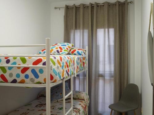 a bedroom with a bunk bed and a chair at Cozy holiday home in a charming area in Montilla