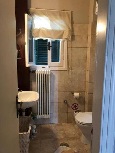 a bathroom with a sink and a toilet and a window at MeadowView Spacious renovated ground floor studio in Análipsis
