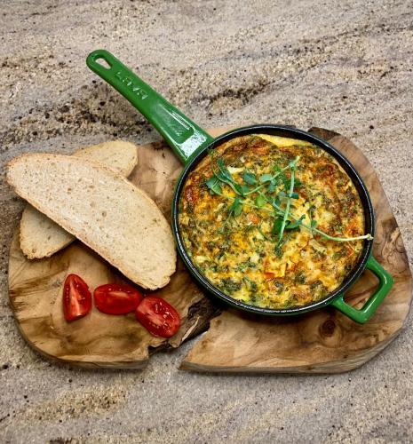 a pot of soup with a spoon and a slice of bread at Apartamenty MonteVerde w Świeradowie-Zdroju in Świeradów-Zdrój