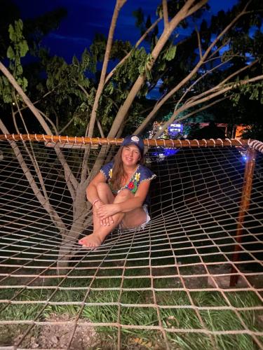 a woman sitting on top of a net at Mangoo Glamping in Melgar