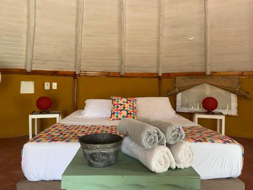Habitación con 2 camas y una mesa con toallas. en Mangoo Glamping, en Melgar