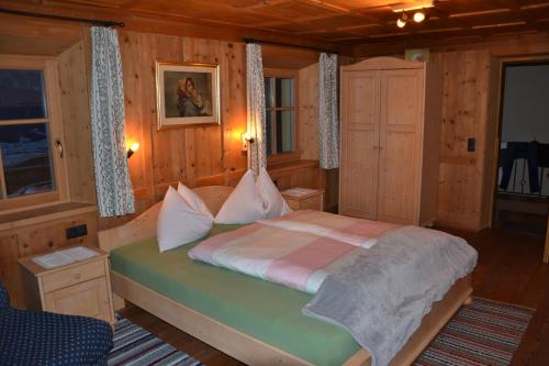 a bedroom with a bed in a wooden room at Gostnerhof in Dobbiaco