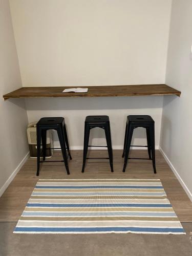a room with two stools and a table in a room at Mission Retreat in Kerikeri