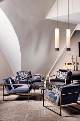 a living room with three chairs and a table at Telegraphenamt in Berlin