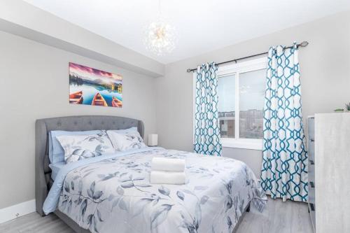 Schlafzimmer mit einem Bett mit blauen Vorhängen und einem Fenster in der Unterkunft Modern & Stylish 1-Bedroom Unit in Edmonton
