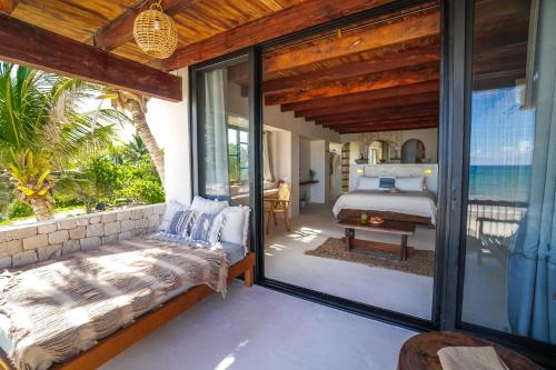 a bedroom with a bed and a view of the ocean at Amansala Resort in Tulum