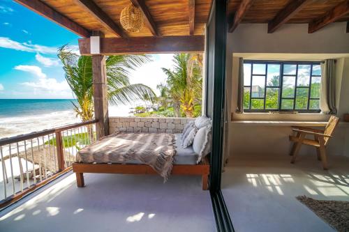 a bedroom with a bed on a balcony with the ocean at Amansala Resort in Tulum
