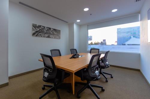 a conference room with a wooden table and black chairs at Sleep Inn Leon Antares in León