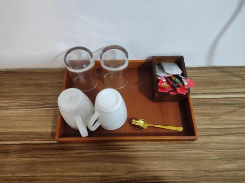 a tray with cups and glasses on a table at Villagewaves in Himmafushi