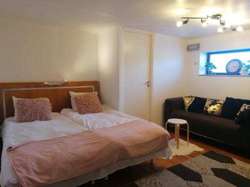 a bedroom with a bed and a couch at Ett rums lägenhet med egen ingång, parkering in Örebro