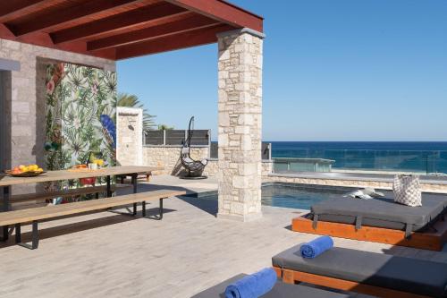 a villa with a swimming pool and a patio at Southrock Villas in Lachania