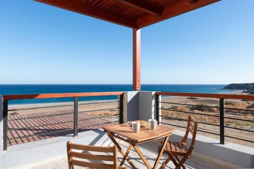a table and chairs on a balcony with a view of the beach at Southrock Villas in Lachania