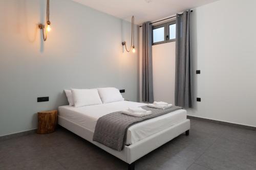 a white bed in a room with a window at Southrock Villas in Lachania