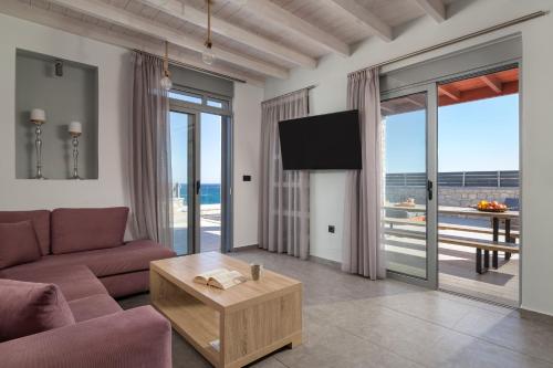 a living room with a couch and a tv at Southrock Villas in Lachania