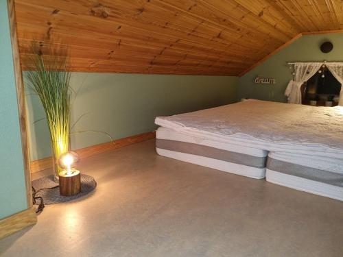 um quarto com uma cama e um candeeiro em Lillastugan Sätuna em Falköping