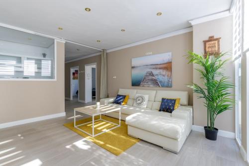 a living room with a white couch and a table at Apartamento con sol de paz in Torremolinos