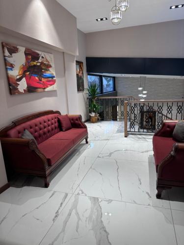 a living room with a red couch and a fireplace at Özkaya hotel in Sivas
