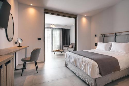 尼基季的住宿－Lagomandra Luxury Suites with Private Pools，一间卧室配有一张床、一张桌子和一张沙发