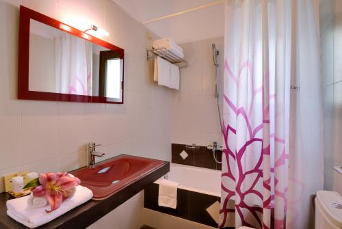 ein Badezimmer mit einem roten Waschbecken und einem Spiegel in der Unterkunft Byzantinon Hotel in Leonidi