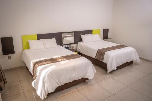 two beds in a hotel room withacers at Hotel SanJo in San José Iturbide