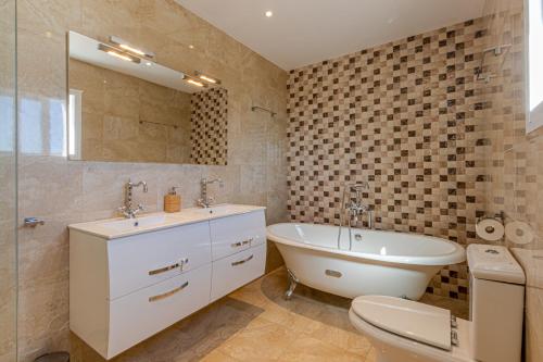 La salle de bains est pourvue d'un lavabo, d'une baignoire et de toilettes. dans l'établissement Luxury Villa Andalucia Seaview Private Pool close to Centre, à Benalmádena