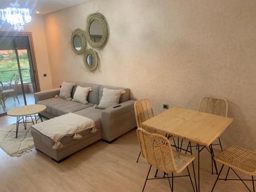 a living room with a couch and a table and chairs at Prestigia jade Marrakech ENTREE 191 APPARTEMENT 9 in Marrakesh