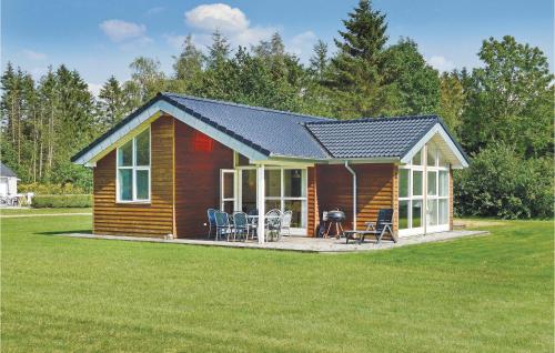 a log cabin with a pitched roof on a lawn at Holiday Home Lyngshuse Herning Iv in Kølkær