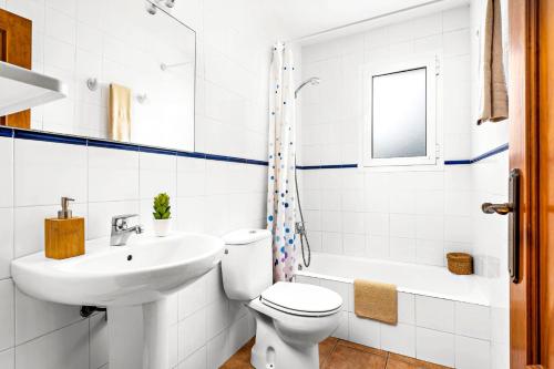 a white bathroom with a toilet and a sink at Villa Bini Anna by Villa Plus in Binibeca