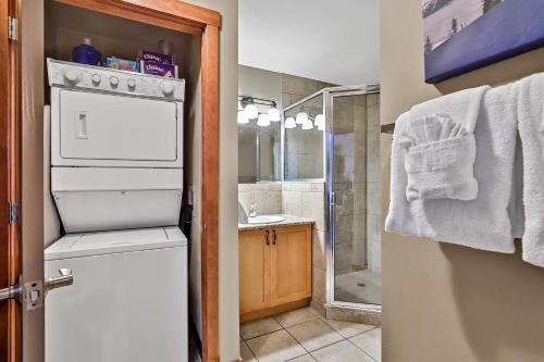 y baño con lavabo, lavadora y secadora. en Fenwick Vacation Rentals Inviting Rocky Mountain HOT TUB in Top Rated Condo, en Canmore