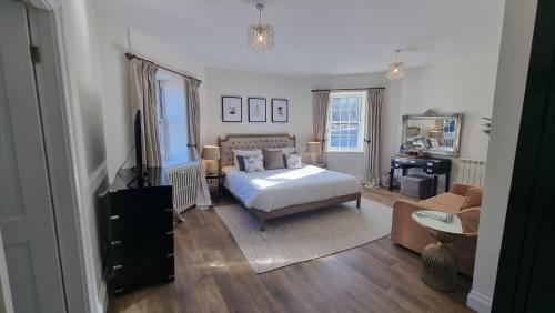 a bedroom with a bed and a television and a couch at Fox & Hounds Country Hotel in Chulmleigh