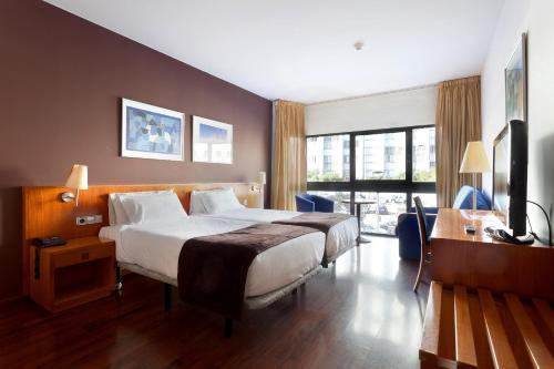 a hotel room with a large bed and a desk at Hotel Viladomat in Barcelona