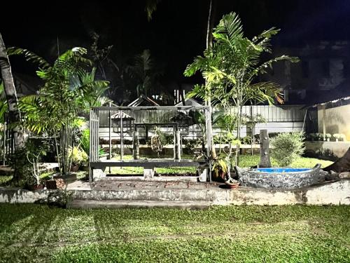 a park bench in a yard at night at Achapas Garden Villla in Kondotti