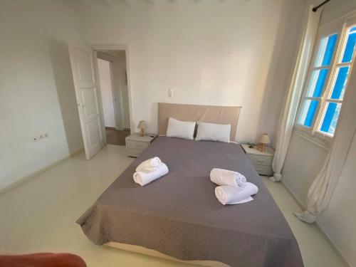 a bedroom with a bed with two towels on it at Fabrica Sunset Apartments in Megali Ammos