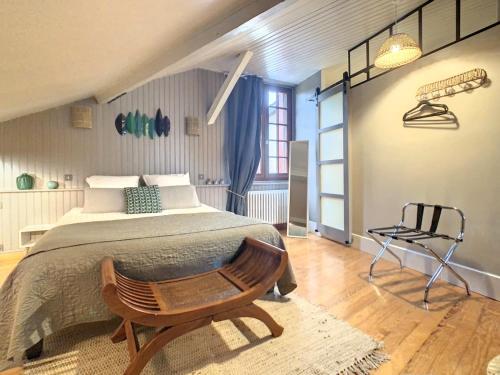 1 dormitorio con 1 cama grande y 1 silla en Les Glycines de Monchy- Chambres d'hôtes, en Monchy-Humières