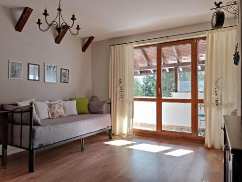 a living room with a couch and a large window at Студио "Птича Песен" - Studio "Birdsong", Смолянски езера in Smolyan