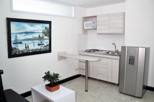 uma cozinha branca com um lavatório e uma mesa em Eslait Hotel & Apartamentos em Barranquilla