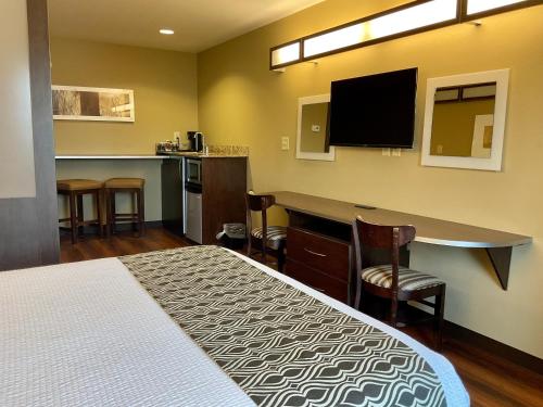 a room with a bed and a bar with a tv at SureStay Plus Hotel by Best Western Buckhannon in Buckhannon
