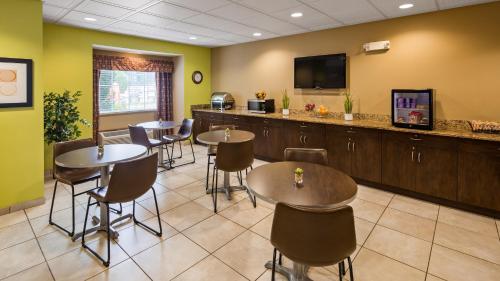a waiting room with tables and chairs and a flat screen tv at SureStay Plus Hotel by Best Western Buckhannon in Buckhannon