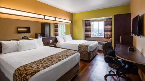 a hotel room with two beds and a desk at SureStay Plus Hotel by Best Western Buckhannon in Buckhannon