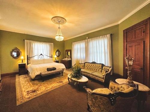 a bedroom with a bed and a couch at The Mansion on 17th, formerly Schaefer Haus in Galveston