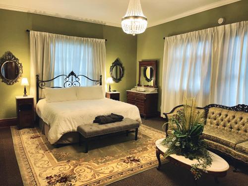 a bedroom with a bed and a couch at The Mansion on 17th, formerly Schaefer Haus in Galveston