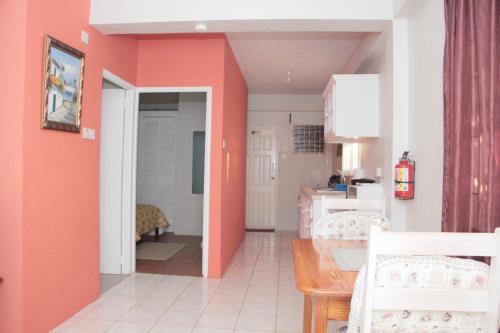 a kitchen with orange walls and a dining room at Buttercup Cottage Apartments in Arnos Vale