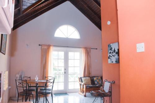 a dining room with a table and chairs and a window at Buttercup Cottage Apartments in Arnos Vale