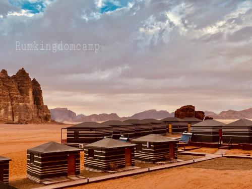 a group of tents in the desert with mountains at Rum Kingdom Camp in Wadi Rum