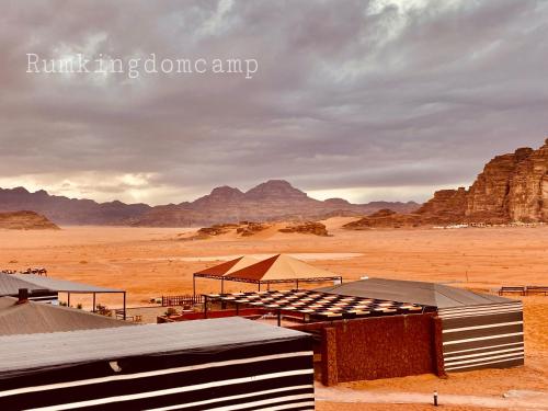 uma cena de deserto com montanhas e edifícios no deserto em Rum Kingdom Camp em Wadi Rum